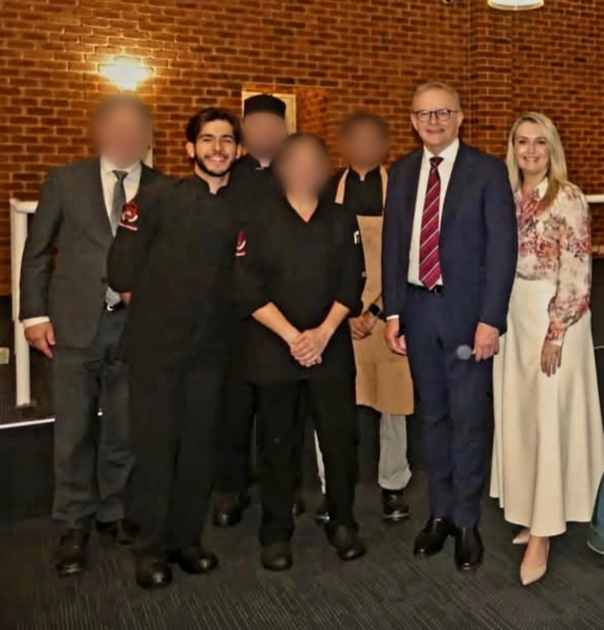 Vitor with the cooking team, Australia’s Prime Minister and his partner during a visit to Perth; other team members’ faces blurred for privacy.